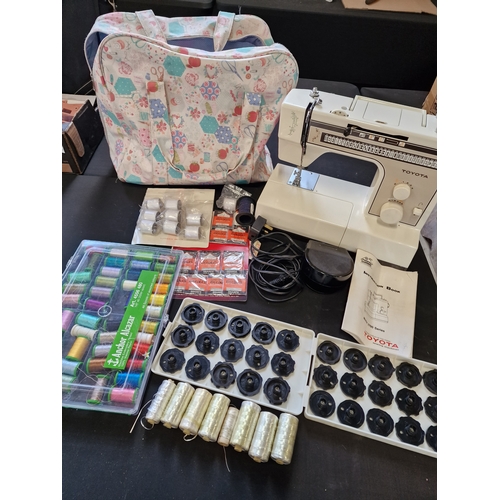 176 - A Toyota sewing machine model no. 2700. Working. Comes with pedal, instructions brand new needles, m... 