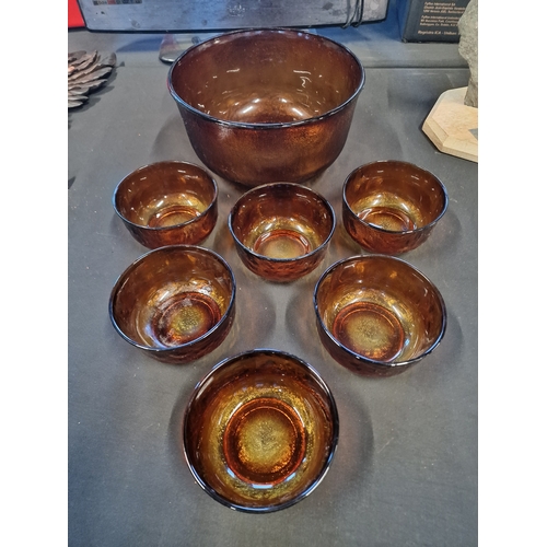 76 - A large vintage amber glass punch bowl with 6 serving glasses/bowls