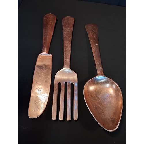 151 - Oversized Copper Coloured Wall Mountable Cutlery Set. Fork, Knife and Spoon. All Approx 60cm Length.