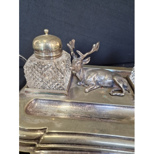 192 - Victorian English Silverplate Ink Stand
An Elk rests between two cut glass ink pots and two quill pe... 