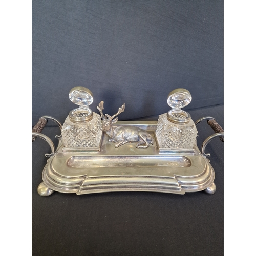 192 - Victorian English Silverplate Ink Stand
An Elk rests between two cut glass ink pots and two quill pe... 