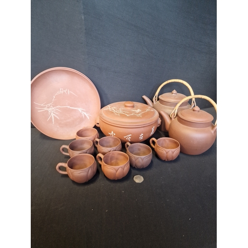 213 - A collection of Terracotta table ware.  Includes two plates, 7 tea cups, serving bowl, coffee and te... 