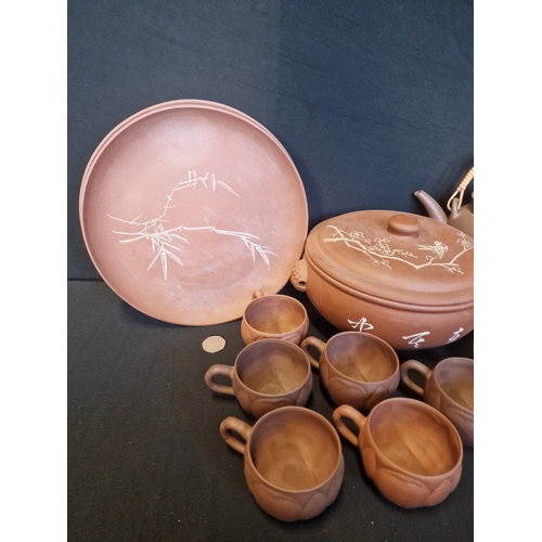 213 - A collection of Terracotta table ware.  Includes two plates, 7 tea cups, serving bowl, coffee and te... 