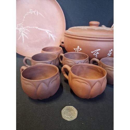 213 - A collection of Terracotta table ware.  Includes two plates, 7 tea cups, serving bowl, coffee and te... 