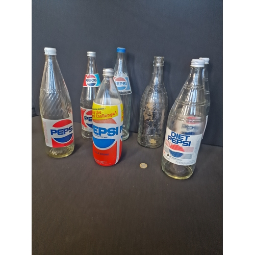 221 - A collection of 1 litre and 1.12 litre PEPSI bottles.  7 different designs, shapes and sizes.