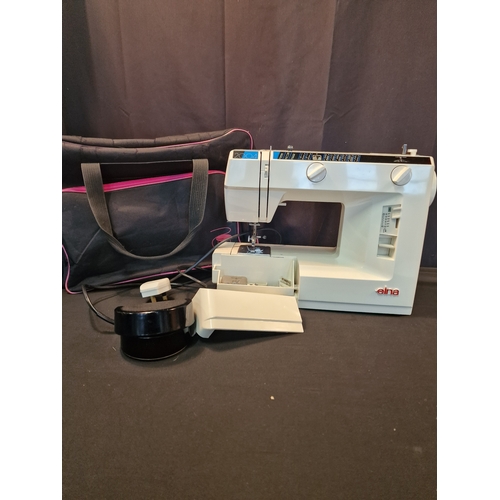 124 - An EINA 2004 sewing machine.  Complete with power cable and pedal also carry bag