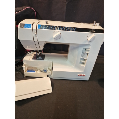 124 - An EINA 2004 sewing machine.  Complete with power cable and pedal also carry bag