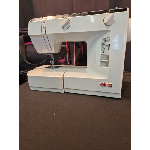 124 - An EINA 2004 sewing machine.  Complete with power cable and pedal also carry bag