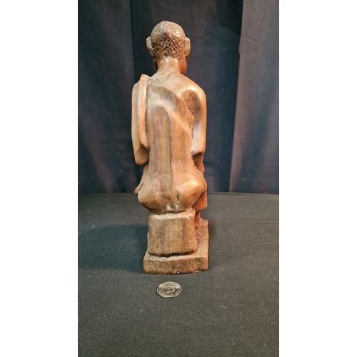 29 - A hand carved African man smoking a pipe.  In African Hardwood Approximately 30cm H