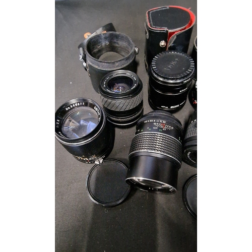 133 - A large collection of 8 vintage camera lenses and cases and accessories