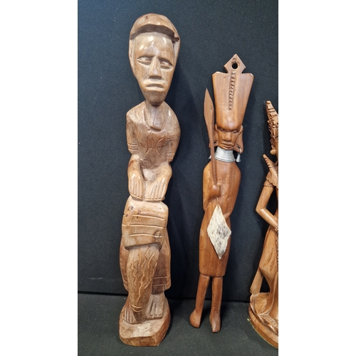 312 - Three hand carved figures of mixed woods.  An Indonesian lady, and two tribal figures