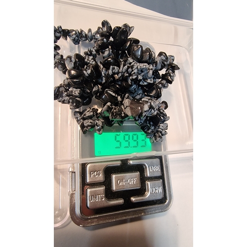 455 - A collection of snow flake obsidian 
Weight 55.93g approximately (the weight of the container has be... 