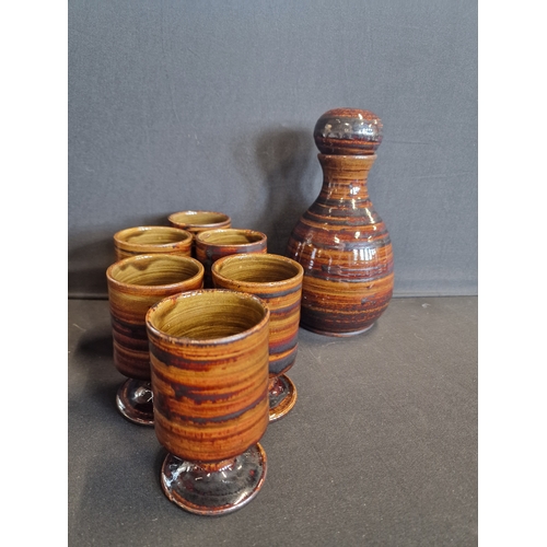 61 - A hand made ceramic tiger design decanter and goblet set. Initialed KN to the base.