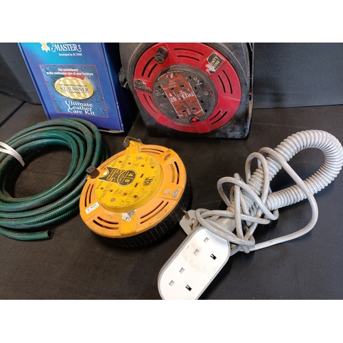 299 - Selection of power extension leads, a hosepipe and a leather care kit