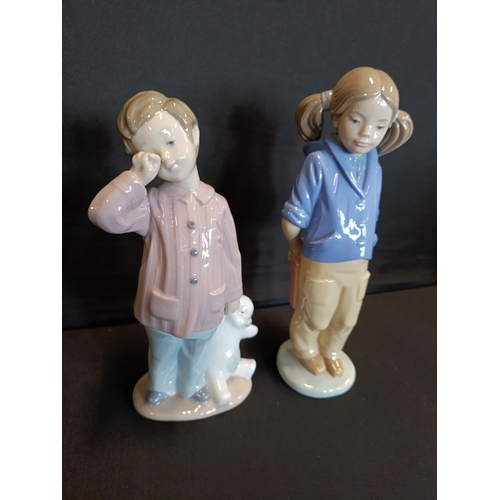 310 - 2 Nao by Lladro figurines, Girl with pigtails and satchel and Sleepy boy with teddy bear