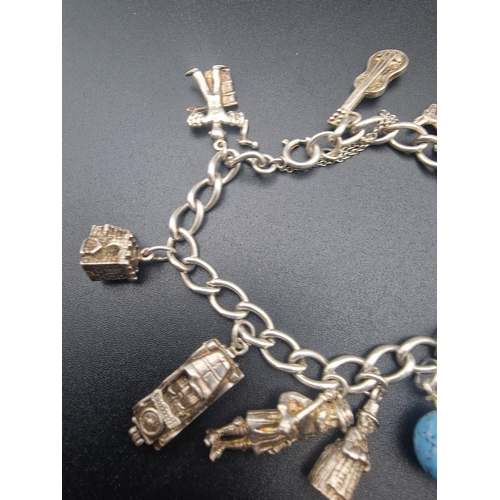 214 - A vintage sterlingnsilver charm bracelet  with 10 sterling charms of various designs