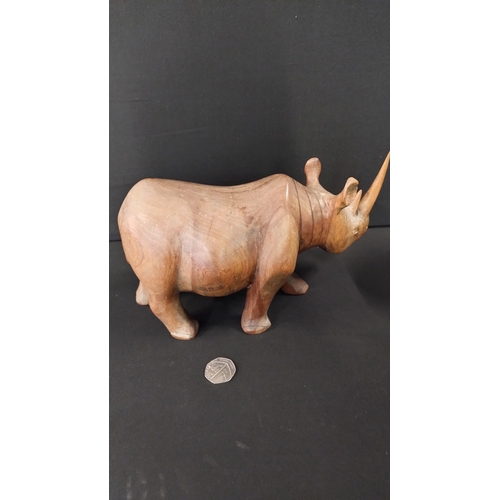 391 - Solid wooden rhino approximately 14 x 27 cm and small elephant 8 x 6 cm