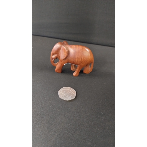 391 - Solid wooden rhino approximately 14 x 27 cm and small elephant 8 x 6 cm