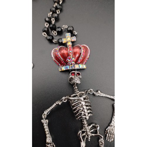 11 - Butler and Wilson Crystal Hanging Skeleton Necklace approximately 37 cm /14 in length, red enamel an... 