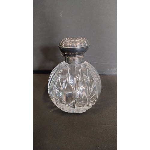 101 - Perfume bottle with a sterling silver hallmarked top and stopper, measures approx H 5 x W 4 in