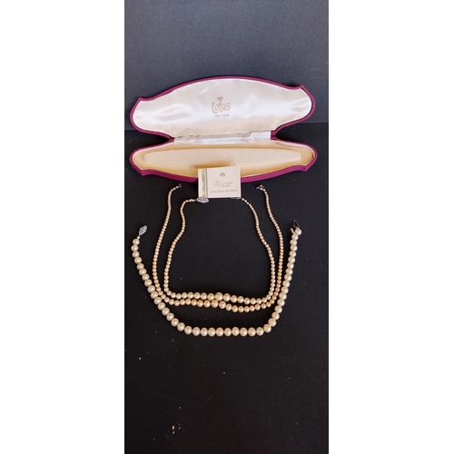 158 - 3 x  simulated pearl necklaces in a red and cream lined lotus De lux box