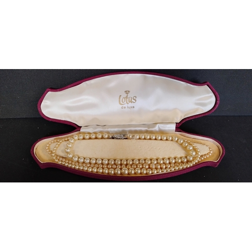 158 - 3 x  simulated pearl necklaces in a red and cream lined lotus De lux box