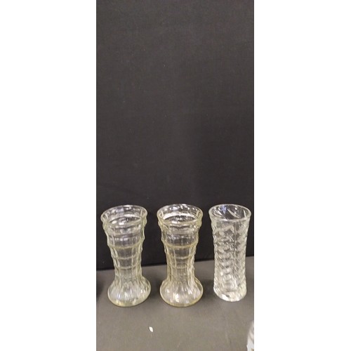 284 - Collection of pin wheel crystal vases, barrel vases, silver plated flower posy vase and other items