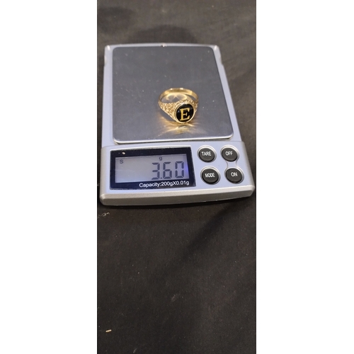 388 - 9 ct gold mens signet ring with initial E inside a black stone. Size S/T. Weight approx 3.60g