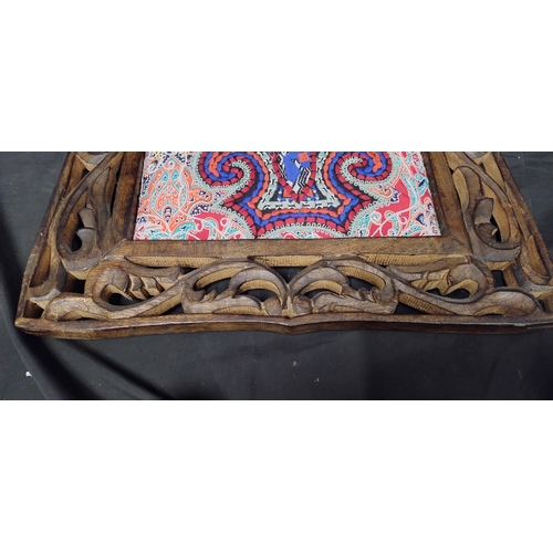 76 - Dark wood carved wall hanging frame with a needlework cushioned design in the centre. Measures appro... 