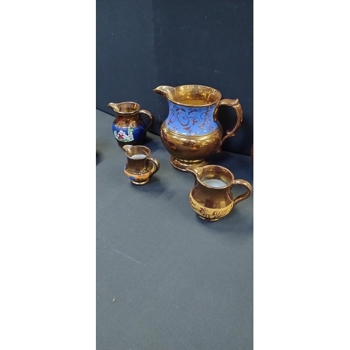 219 - Selection of copper luster ware blue stripe jugs and a brown stoneware jug