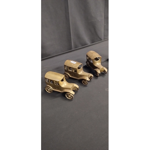 159 - 3 brass vintage cars and a brass boot with rake shovel and spade