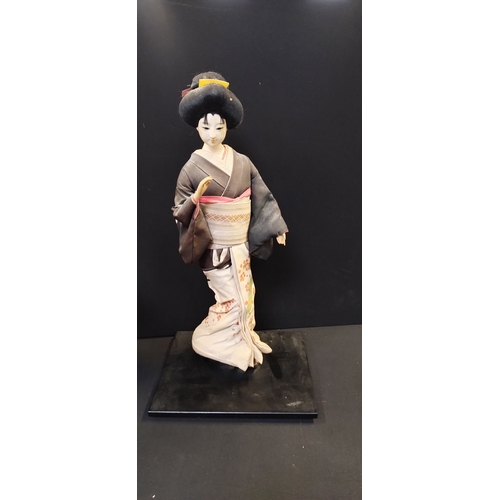 187 - Two oriental collectors dolls on stands