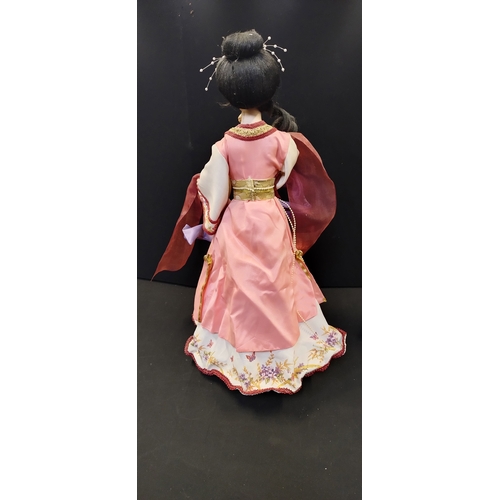 187 - Two oriental collectors dolls on stands