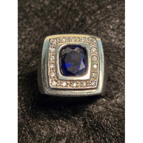 18 - Sterling silver dress ring set with a central blue stone and surround by Cubic Zirconia stones. Size... 