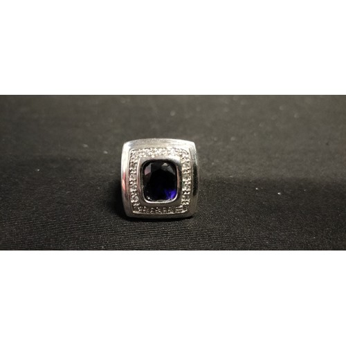 18 - Sterling silver dress ring set with a central blue stone and surround by Cubic Zirconia stones. Size... 