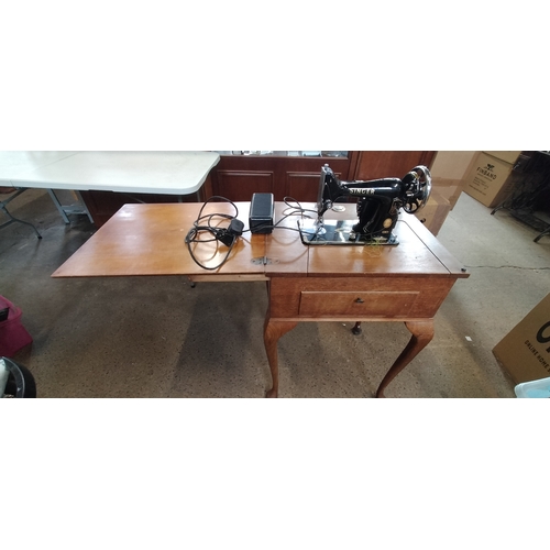 93 - Vintage singer sewing machine recessed in wooden folding sewing table. Measures approx H 82.5 x W 57... 