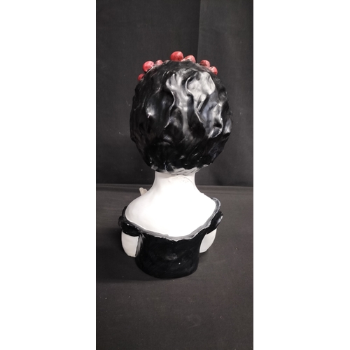 106 - polyresin candy scull with red flower headband holding flowers. Measures approx H 31.5 x W 15.5 x D ... 