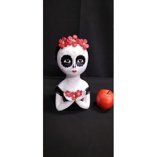 106 - polyresin candy scull with red flower headband holding flowers. Measures approx H 31.5 x W 15.5 x D ... 