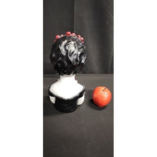 106 - polyresin candy scull with red flower headband holding flowers. Measures approx H 31.5 x W 15.5 x D ... 