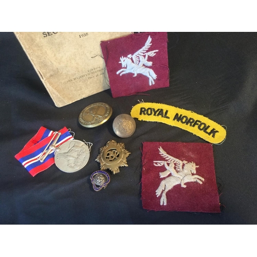 29 - WW2 BRITISH AIRBORNE ROYAL NORFOLK MEDAL AND PATCH GROUP WITH 1938 INFANTRY TRAINING BOOK