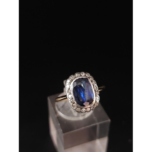 57 - A sapphire and diamond cluster ring, a cushion shaped mixed cut sapphire approx 6mm x 9mm. Weight 2.... 