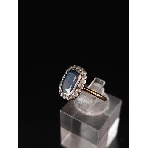 57 - A sapphire and diamond cluster ring, a cushion shaped mixed cut sapphire approx 6mm x 9mm. Weight 2.... 