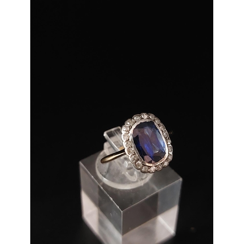 57 - A sapphire and diamond cluster ring, a cushion shaped mixed cut sapphire approx 6mm x 9mm. Weight 2.... 