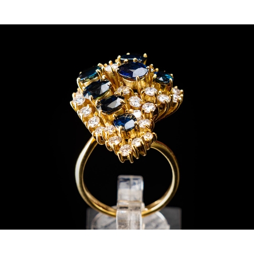 63 - Stunning cocktail ring set in 18ct gold featuring a nest of 8 6.5mm by 4.5mm sapphires surrounded by... 