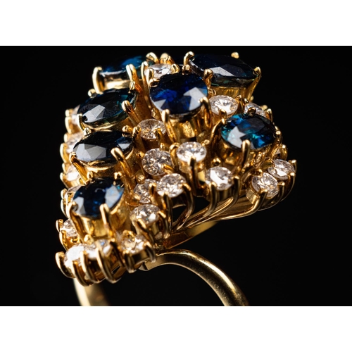 63 - Stunning cocktail ring set in 18ct gold featuring a nest of 8 6.5mm by 4.5mm sapphires surrounded by... 