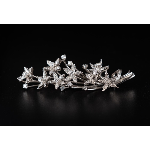 64 - Vintage brooch crafted in 18ct white gold made to resemble a floral branch with leaves. Set with 15 ... 