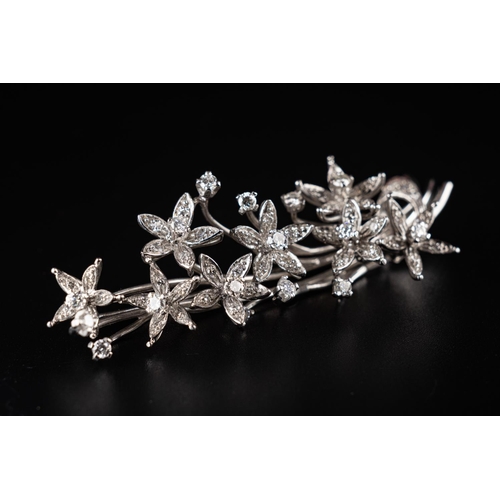 64 - Vintage brooch crafted in 18ct white gold made to resemble a floral branch with leaves. Set with 15 ... 