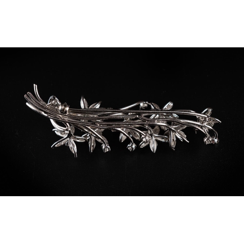 64 - Vintage brooch crafted in 18ct white gold made to resemble a floral branch with leaves. Set with 15 ... 