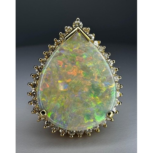 77 - 18ct yellow gold opal and diamond ring. With a 12 mm x 20 mm pear shaped opal surrounded 
By 35 Dias... 