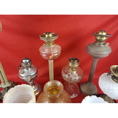 337 - Collection of 6 oil lamps with various glass shades.